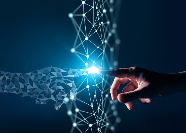 Eine menschliche und eine digitale Hand berühren sich vor einem leuchtenden Netz aus Knotenpunkten